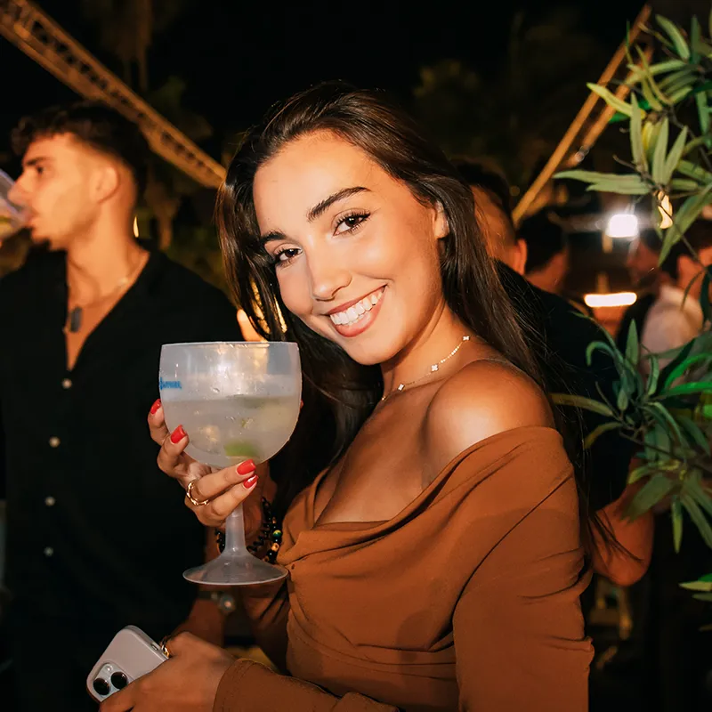 Beautiful girl with Gin drink in hand posing for photo Lust in Rio