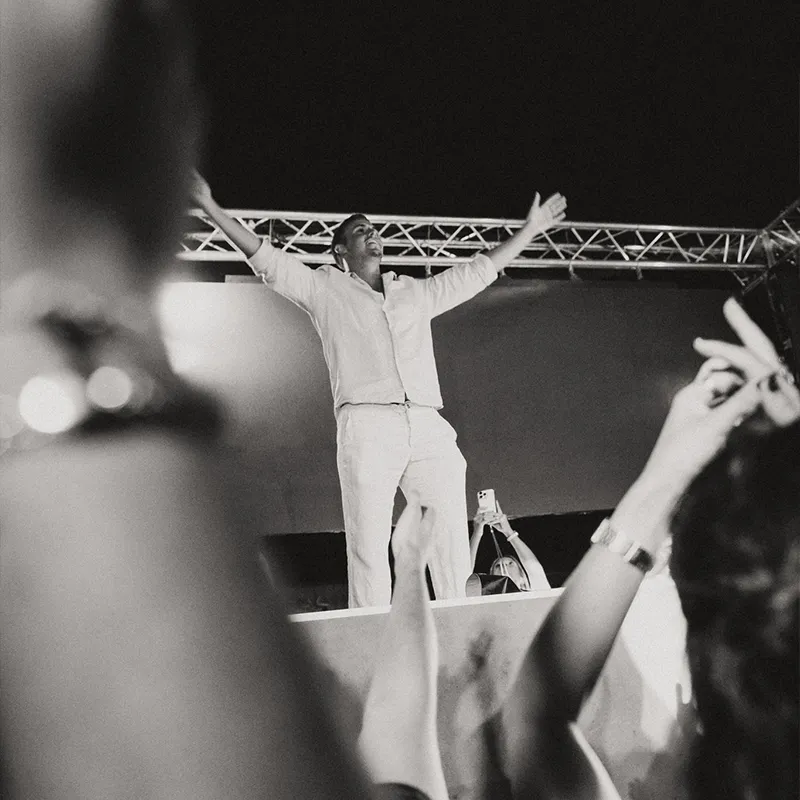 Man in DJ booth dancing and having fun with crowd black and white Lust in Rio